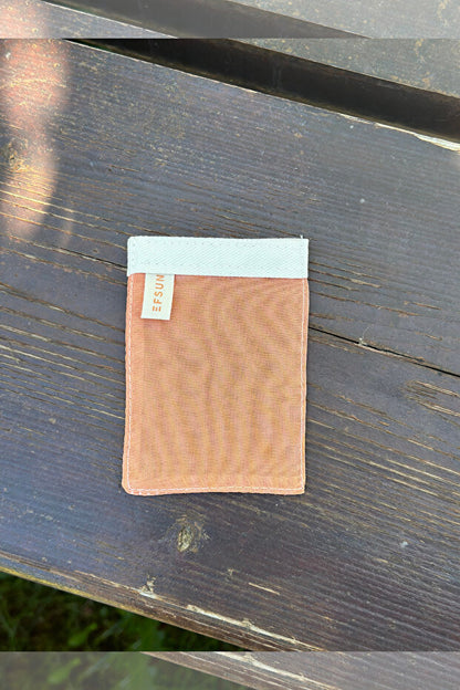 Brown leather wallet with a white label on a dark wooden surface