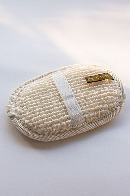 Beige exfoliating pad with a brand label on a white background